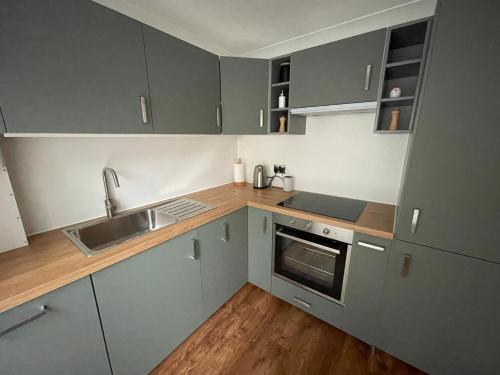 a kitchen with gray cabinets and a sink at Hydeaway beautiful 3 bedroom house in a great location in Bournemouth