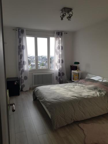 a bedroom with a bed and a large window at Chambre Céleste in Tours