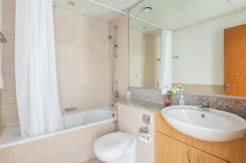 W łazience znajduje się umywalka, toaleta i lustro. w obiekcie Frank Porter - Al Sidir 2 w Dubaju