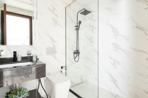 a white bathroom with a shower and a toilet at Frank Porter - Pantheon Elysee II in Dubai