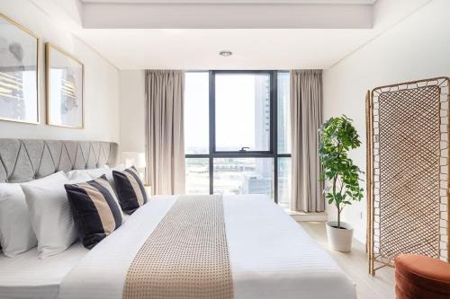 a bedroom with a large bed and a large window at Frank Porter - Goldcrest Views 2 in Dubai