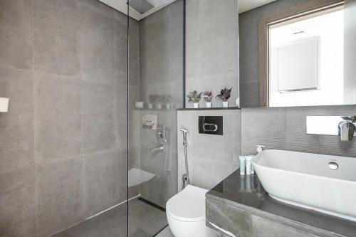 a bathroom with a sink and a toilet and a shower at Frank Porter - Divine Residences in Dubai