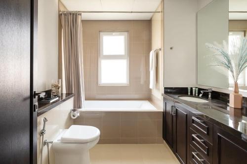 杜拜的住宿－Frank Porter - Serena Casa Viva，一间带卫生间、水槽和窗户的浴室