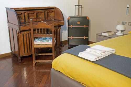 a bedroom with a bed and a dresser and a suitcase at Dimora Altana in Brescia