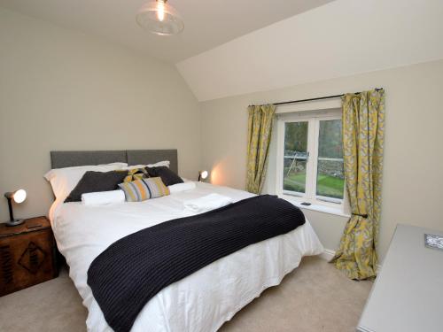 a bedroom with a large bed and a window at 4 Bed in Brassington 47450 in Brassington