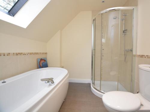 a bathroom with a bath tub and a toilet at 4 Bed in Brassington 47450 in Brassington