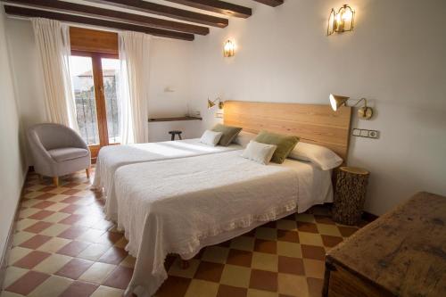 1 dormitorio con 2 camas y 1 silla en El Patio de la Morera, en El Rasillo