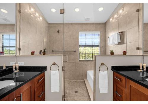 a bathroom with a shower and a sink and a tub at Luxury Model Townhome - 5 minutes from Disney in Orlando