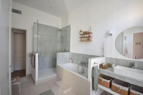 une salle de bain avec une baignoire, un lavabo et un miroir dans l'établissement Coeur Longchamp, Grand Haussmannien, à Marseille