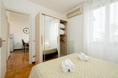 Un dormitorio con una cama con toallas blancas. en Apartment Soleil - Sole del Garda, en Lazise