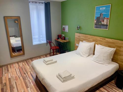 アグドにあるLogis Hotel Yseria - Historical Centerのベッドルーム1室(大型ベッド1台、白い枕、鏡付)