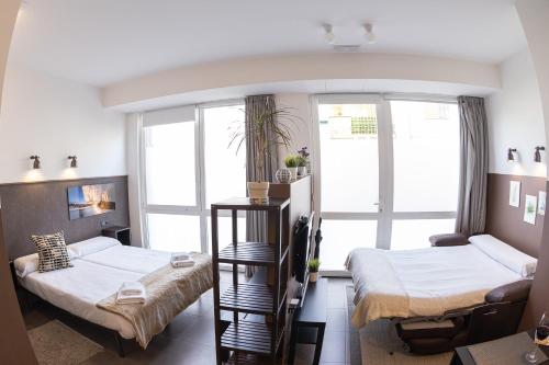 a room with two beds and a window at Zarautz SALBIDE APARTMENTS in Zarautz