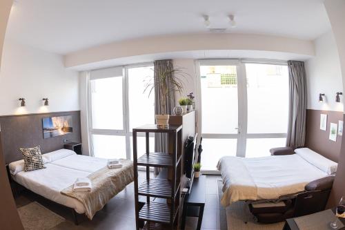 a room with two beds and a window at Apartamentos Salbide Zarautz in Zarautz
