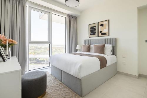 a white bedroom with a bed and a window at Frank Porter - 1 Residences 2 East Tower in Dubai