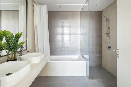 bagno con vasca, lavandino e doccia di Frank Porter - 1 Residences 2 East Tower a Dubai
