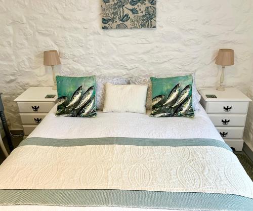 a bedroom with a bed with two white night stands at The Old Post House B&B in St Just