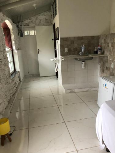 歐魯普雷圖的住宿－Casa do Chá Ouro Preto，一间铺有白色大瓷砖地板的浴室和一间房间