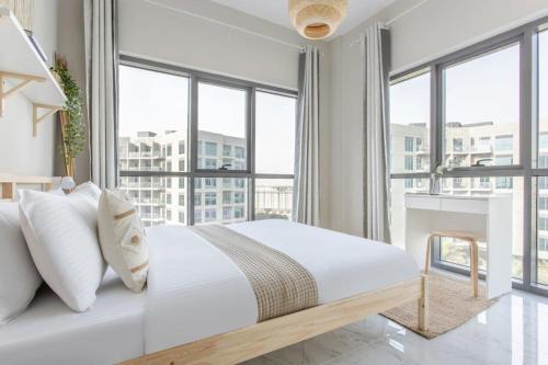 Schlafzimmer mit einem großen weißen Bett und Fenstern in der Unterkunft Frank Porter - MAG 560 in Dubai