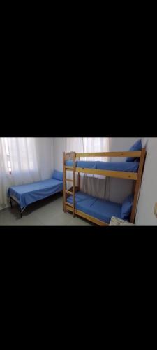 Ce dortoir comprend 2 lits superposés avec des draps bleus. dans l'établissement Apartament Cornerstone, à Shkodër