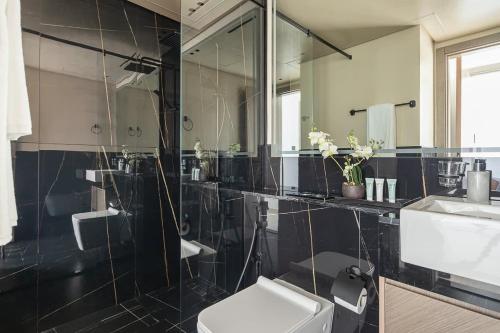 a bathroom with a toilet and a large mirror at Frank Porter - Binghatti Creek in Dubai