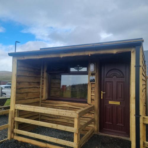 a small house with a door and a window at Standing Stones Lodge in Belfast