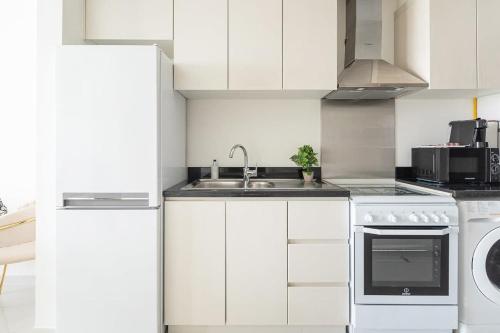 a white kitchen with a sink and a dishwasher at Frank Porter - Carson A in Dubai Marina