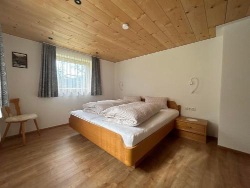 Schlafzimmer mit einem Bett mit Holzdecke in der Unterkunft Haus Lechner in Gaschurn