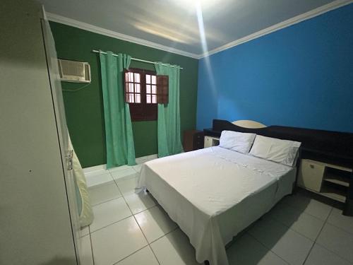 niebieska sypialnia z łóżkiem i oknem w obiekcie Casa de Lazer Praia e Piscina w mieście São José da Coroa Grande