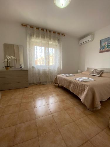 a bedroom with a bed and a large window at IL TULIPANO in Civitavecchia