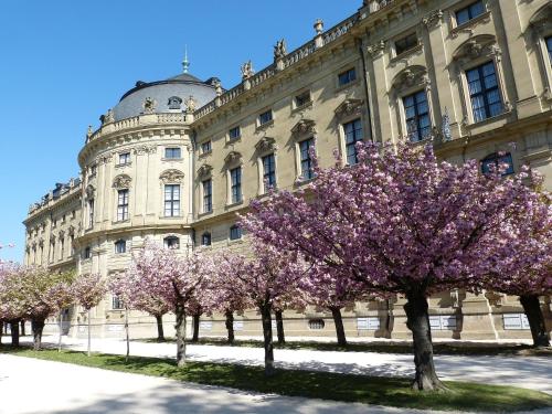 a building withakura trees in front of it at Best Western Hotel Würzburg-Süd in Würzburg