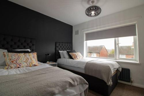 a bedroom with two beds and a window at K Suites - Lime Grove in Ryton