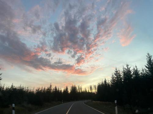 an empty road with a cloudy sky at sunset at Apartment KY481 im PanoramicHohegeiß in Braunlage