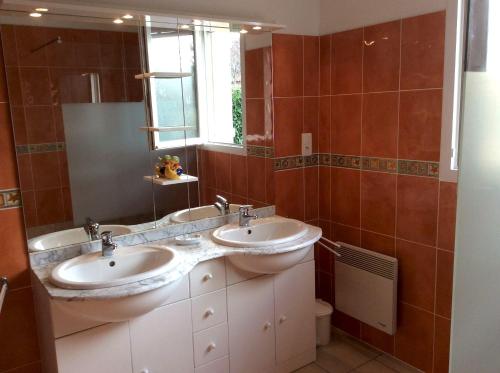 ein Badezimmer mit 2 Waschbecken und einem Spiegel in der Unterkunft Villa de 3 chambres avec piscine privee jardin clos et wifi a Loubressac in Loubressac