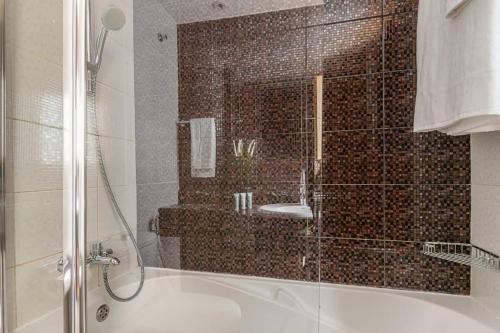 a bathroom with a shower with a tub and a sink at Frank Porter - Zumurud Tower, Dubai Marina in Dubai