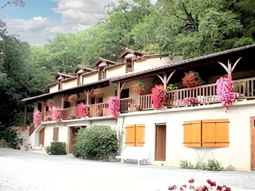 a building with pink flowers on the balconies at Villa confortable à Milhars avec piscine privée in Milhars