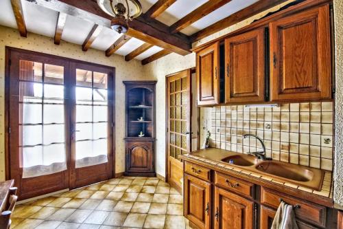 eine Küche mit Holzschränken und einem Waschbecken in der Unterkunft Villa de 4 chambres avec piscine privee jardin clos et wifi a Milhars in Milhars