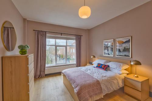a bedroom with a bed and a large window at Avenue Apartment in Belfast