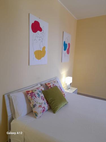 um quarto com uma cama branca com almofadas em CIVICO 26 em Bisceglie