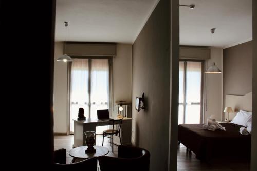 a room with a bed and a desk with a laptop at Art Hotel Pandos in Tabiano