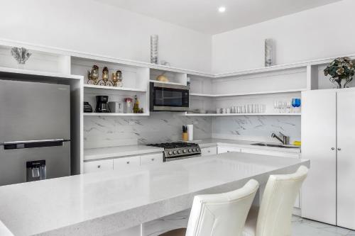 a white kitchen with a white counter and white appliances at Casa 12 - Playa Arcangel in Rosarito