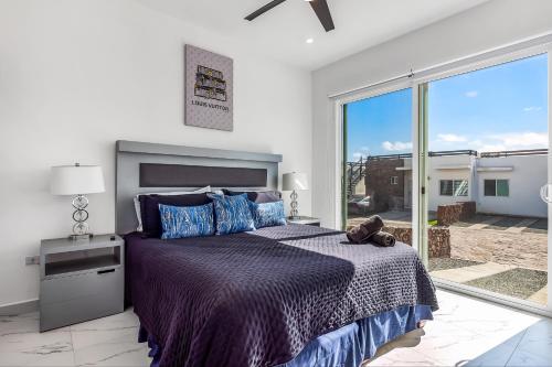 a bedroom with a bed and a large window at Casa 12 - Playa Arcangel in Rosarito