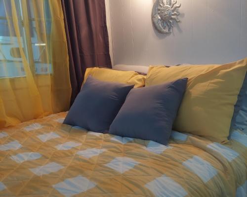 Una cama con dos almohadas azules encima. en Cute & Cozy Houseboat Near Chattanooga en Haletown