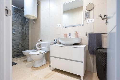 Baño blanco con aseo y lavamanos en Casa de invitados para 6 personas, en Carmona