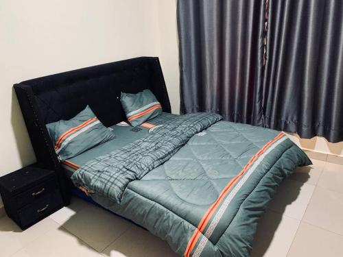 - un lit avec une tête de lit et des oreillers noirs dans l'établissement Exquisite Apartments- 1Bedroom with nice view of Kigali City, Playground for kids, Close to Amusement Park, à Kigali