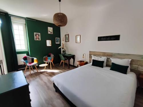 a bedroom with a large bed and a green wall at Hotel Abat Jour in Nantes