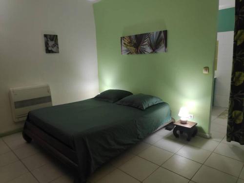 a bedroom with a bed and a table with a lamp at Gite Bambou, face à la mer in Pointe-Noire