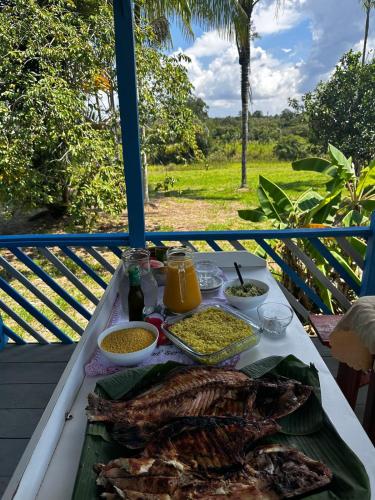 una mesa con una bandeja de comida en el balcón en Vista do Ubim en Paricatuba