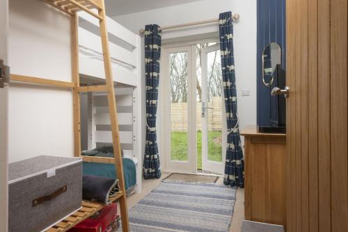 ein Schlafzimmer mit einem Etagenbett und einem Fenster in der Unterkunft Lobbs Cottage, St Mawgan in Saint Mawgan