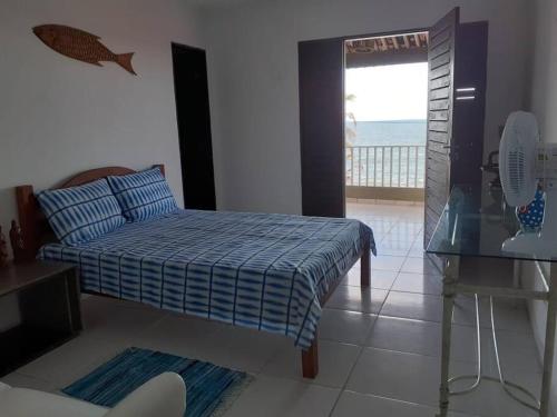 um quarto com uma cama e vista para o oceano em Breeze & Shade Beira Mar em Parnamirim