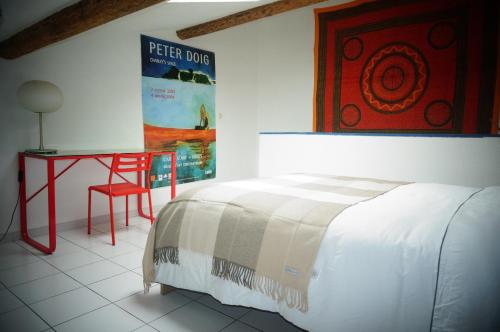 a bedroom with a bed and a table and a poster at LaCour in Nîmes